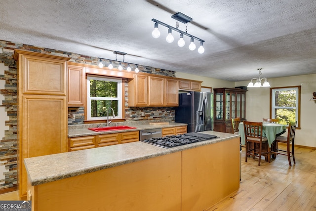 220 Gamble Dr, Carrollton, GA 30116 - kitchen with appliances with stainless steel finishes, light wood-type flooring, a textured ceiling, backsplash, and a chandelier