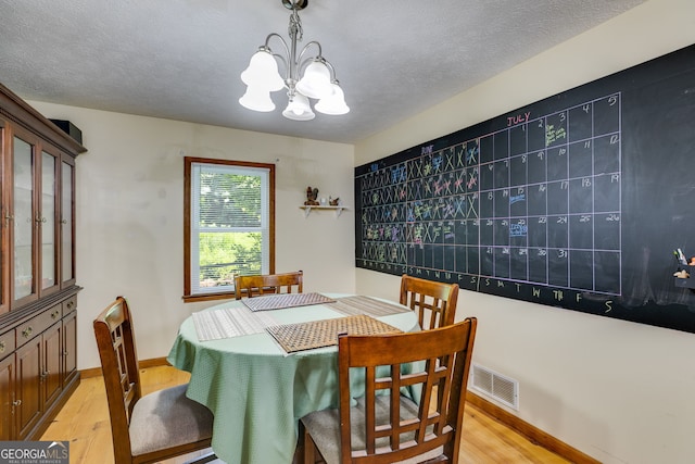 220 Gamble Dr, Carrollton, GA 30116 - dining room featuring light wood finished floors, a chandelier, and a textured ceiling
