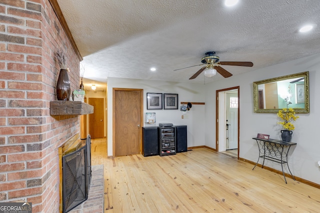 220 Gamble Dr, Carrollton, GA 30116 - living area with light wood-style floors, a textured ceiling, ceiling fan, a fireplace, and recessed lighting