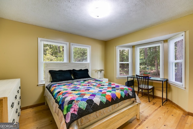 220 Gamble Dr, Carrollton, GA 30116 - bedroom featuring light wood-type flooring, multiple windows, and a textured ceiling