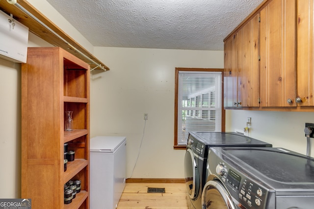220 Gamble Dr, Carrollton, GA 30116 - laundry area with washing machine and dryer, cabinet space, light wood-style floors, and a textured ceiling