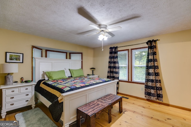 220 Gamble Dr, Carrollton, GA 30116 - bedroom featuring light wood finished floors, a textured ceiling, and a ceiling fan
