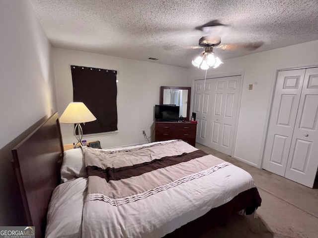 1106 Shiloh Ln NW, Kennesaw, GA 30144 - bedroom with a textured ceiling, light carpet, ceiling fan, and two closets