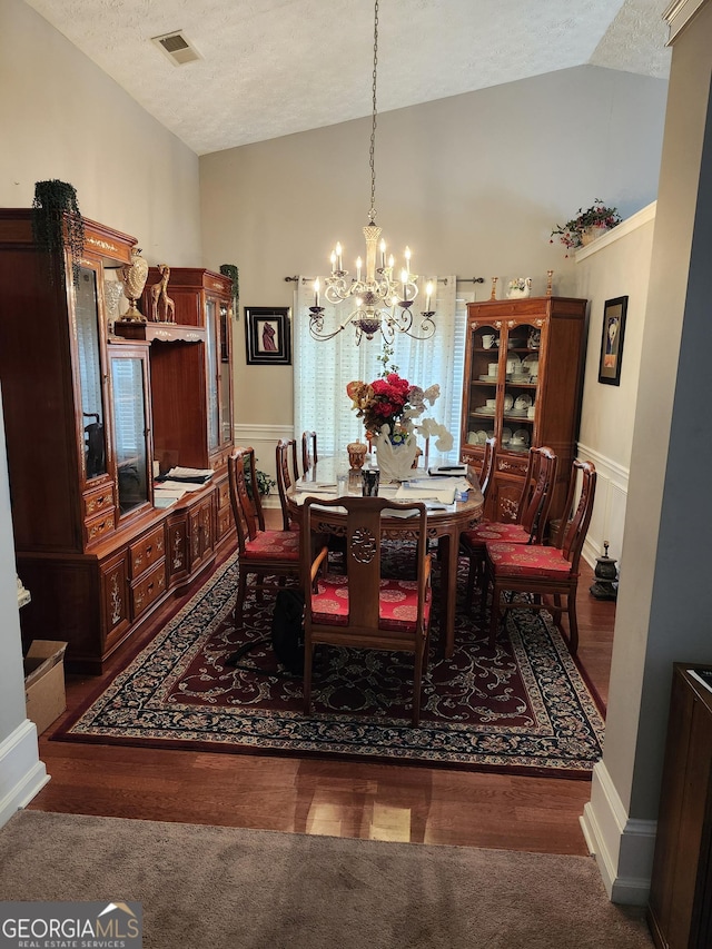 979 Simonton Dr, Lawrenceville, GA 30045 - dining space with lofted ceiling, a chandelier, a textured ceiling, carpet flooring, and wood finished floors