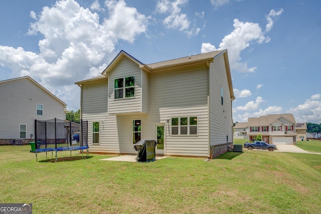 116 Sophie Cir, Locust Grove, GA 30248 - back of house featuring a trampoline, a lawn, and a patio