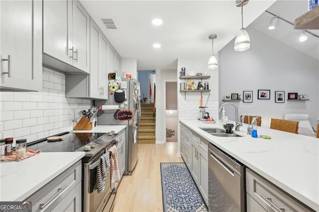 2653 Partridge Trl, Duluth, GA 30097 - kitchen with appliances with stainless steel finishes, light wood finished floors, tasteful backsplash, pendant lighting, and open shelves