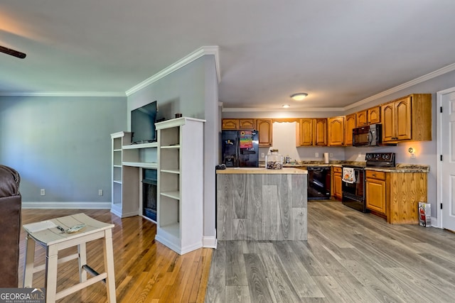 104 View St, Clarkesville, GA 30523 - kitchen with black appliances, light wood finished floors, crown molding, brown cabinets, and a fireplace