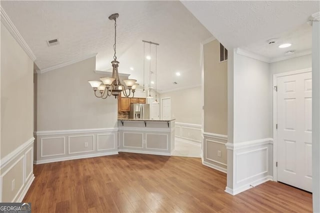 3707 Vineyards Lake Cir NW Unit 22, Kennesaw, GA 30144 - unfurnished dining area featuring a chandelier, light wood finished floors, a decorative wall, crown molding, and wainscoting