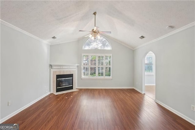 3707 Vineyards Lake Cir NW Unit 22, Kennesaw, GA 30144 - unfurnished living room with ceiling fan, wood finished floors, a tiled fireplace, a textured ceiling, and arched walkways