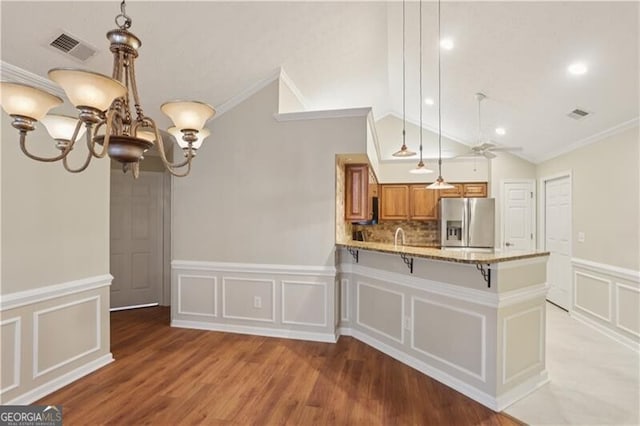 3707 Vineyards Lake Cir NW Unit 22, Kennesaw, GA 30144 - kitchen with stainless steel fridge, brown cabinetry, a decorative wall, crown molding, and a chandelier