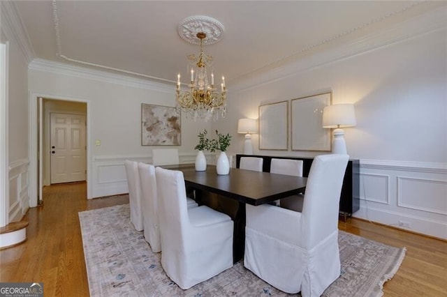 360 Hannaford Dr, Roswell, GA 30075 - dining room featuring a chandelier, a decorative wall, crown molding, wainscoting, and light wood-type flooring