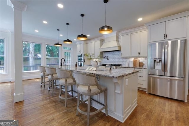 360 Hannaford Dr, Roswell, GA 30075 - kitchen with stainless steel fridge with ice dispenser, premium range hood, a large island, light wood-style flooring, and recessed lighting