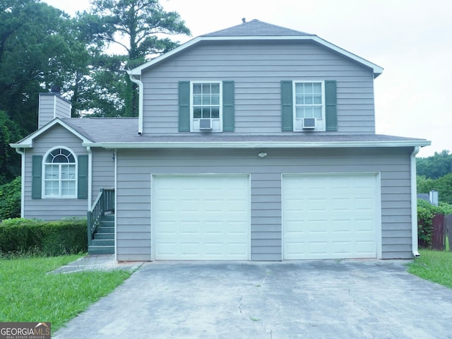 5761 Antelope Trl, Atlanta, GA 30349 - view of front of house featuring driveway, an attached garage, a chimney, and cooling unit