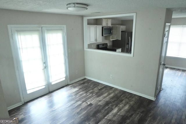5761 Antelope Trl, Atlanta, GA 30349 - unfurnished dining area featuring dark wood-style floors, a textured ceiling, and plenty of natural light