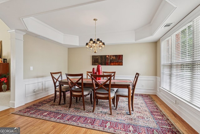 25 Hampreston Ct, Alpharetta, GA 30022 - dining area featuring wood finished floors, a tray ceiling, a wainscoted wall, a chandelier, and decorative columns