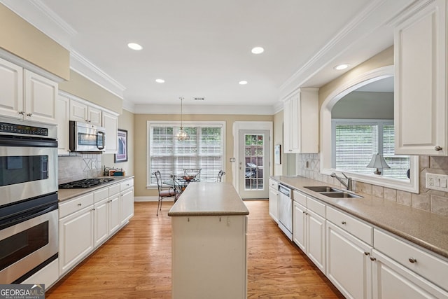 25 Hampreston Ct, Alpharetta, GA 30022 - kitchen with appliances with stainless steel finishes, a center island, decorative backsplash, light wood finished floors, and white cabinets