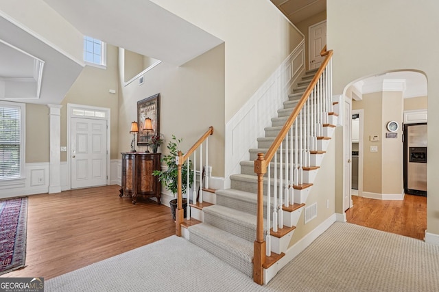 25 Hampreston Ct, Alpharetta, GA 30022 - entryway with a towering ceiling, wood finished floors, arched walkways, stairs, and wainscoting