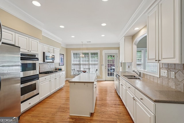 25 Hampreston Ct, Alpharetta, GA 30022 - kitchen featuring stainless steel appliances, a center island, white cabinetry, ornamental molding, and light wood finished floors