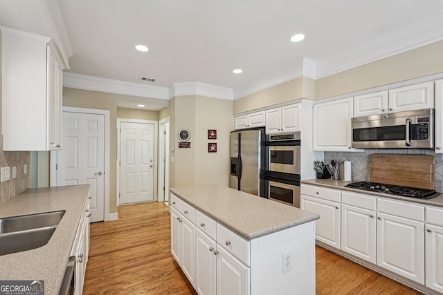 25 Hampreston Ct, Alpharetta, GA 30022 - kitchen with stainless steel appliances, ornamental molding, a center island, tasteful backsplash, and white cabinets
