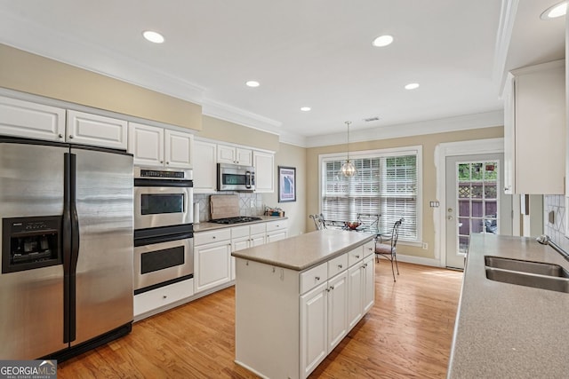 25 Hampreston Ct, Alpharetta, GA 30022 - kitchen with appliances with stainless steel finishes, ornamental molding, light wood-style flooring, white cabinetry, and backsplash