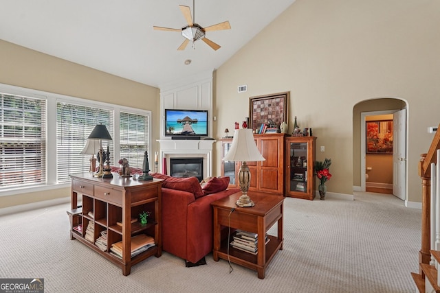 25 Hampreston Ct, Alpharetta, GA 30022 - living area with light carpet, arched walkways, a ceiling fan, a glass covered fireplace, and high vaulted ceiling