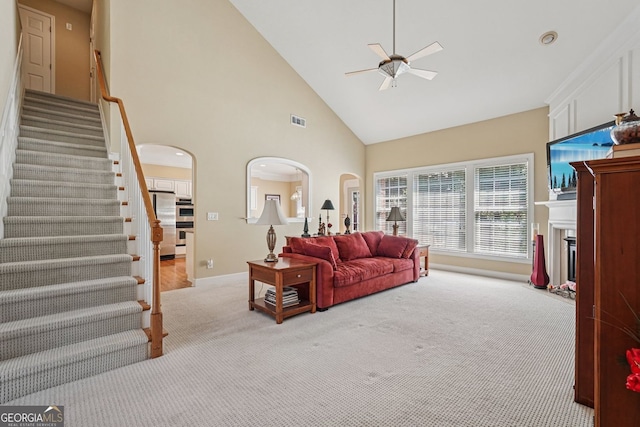25 Hampreston Ct, Alpharetta, GA 30022 - living room featuring carpet floors, arched walkways, ceiling fan, high vaulted ceiling, and stairs