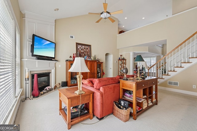 25 Hampreston Ct, Alpharetta, GA 30022 - living room with a ceiling fan, light colored carpet, a glass covered fireplace, stairway, and high vaulted ceiling