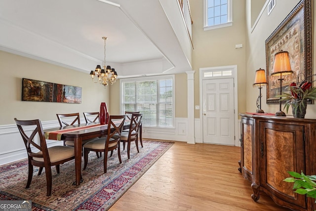 25 Hampreston Ct, Alpharetta, GA 30022 - dining area with light wood-style floors, a chandelier, a decorative wall, wainscoting, and a tray ceiling