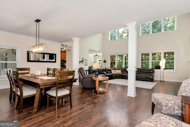 4882 Rabbit Farm Rd, Loganville, GA 30052 - dining area featuring decorative columns, dark wood-type flooring, a high ceiling, and ornamental molding