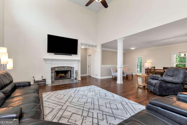 4882 Rabbit Farm Rd, Loganville, GA 30052 - living room featuring ceiling fan, ornate columns, wood finished floors, a high end fireplace, and a towering ceiling