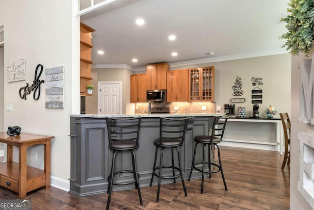 4882 Rabbit Farm Rd, Loganville, GA 30052 - kitchen featuring stainless steel microwave, crown molding, a peninsula, glass insert cabinets, and dark wood-style flooring