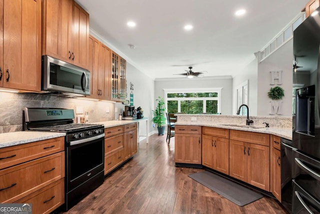 4882 Rabbit Farm Rd, Loganville, GA 30052 - kitchen with stainless steel microwave, gas range, backsplash, dark wood-style floors, and light stone countertops