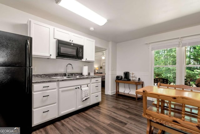 4882 Rabbit Farm Rd, Loganville, GA 30052 - kitchen with black appliances, dark wood-style floors, white cabinetry, a wainscoted wall, and dark stone counters