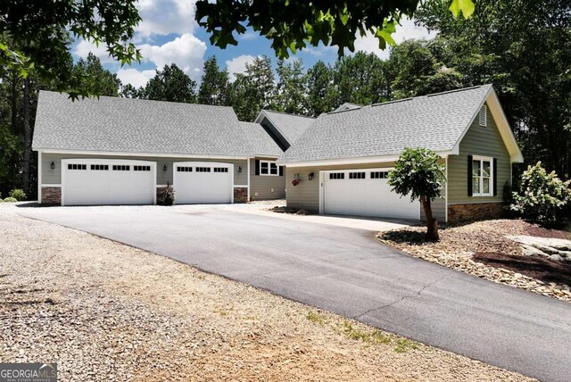 4882 Rabbit Farm Rd, Loganville, GA 30052 - single story home featuring stone siding, asphalt driveway, roof with shingles, and an attached garage