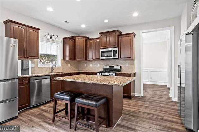 1786 Jameson Cir, Lawrenceville, GA 30043 - kitchen featuring appliances with stainless steel finishes, dark wood-style floors, a center island, dark brown cabinetry, and recessed lighting