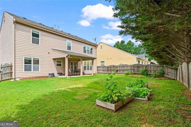 1786 Jameson Cir, Lawrenceville, GA 30043 - rear view of house with a vegetable garden, a fenced backyard, and a patio
