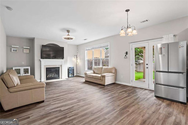 1786 Jameson Cir, Lawrenceville, GA 30043 - living area with wood finished floors, french doors, a glass covered fireplace, and a chandelier