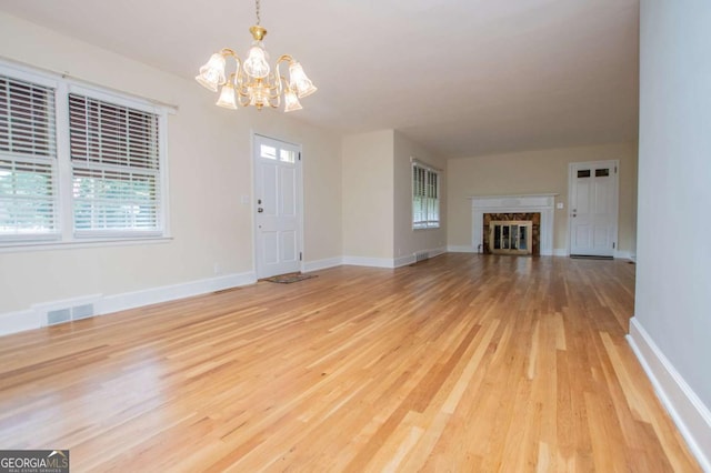 508 College St, Bowdon, GA 30108 - unfurnished living room featuring a chandelier and light wood-type flooring