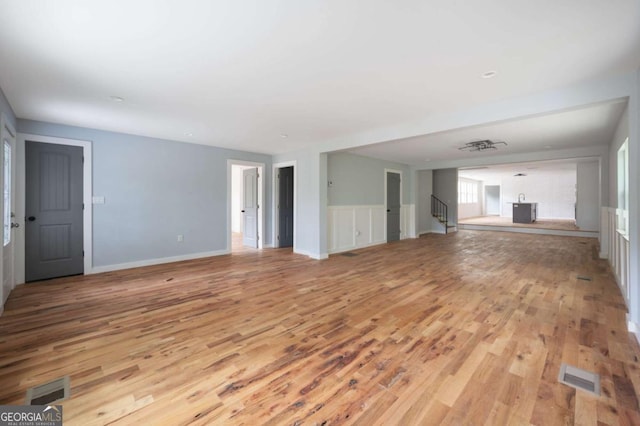 1630 Ezra Church Dr NW, Atlanta, GA 30314 - unfurnished living room featuring light wood-style floors and stairs