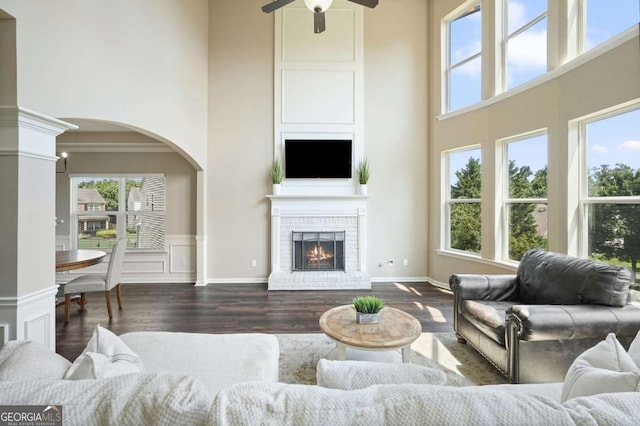6665 Flagstone Ct, Cumming, GA 30028 - living room with a towering ceiling, plenty of natural light, ceiling fan, arched walkways, and wood finished floors
