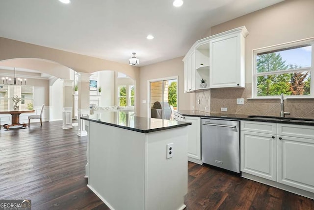 6665 Flagstone Ct, Cumming, GA 30028 - kitchen with stainless steel dishwasher, ornate columns, dark countertops, a center island, and open shelves
