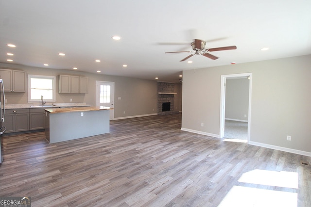 413 Spring Village Rd SE, Lindale, GA 30147 - kitchen featuring open floor plan, gray cabinets, a center island, a ceiling fan, and wood finished floors