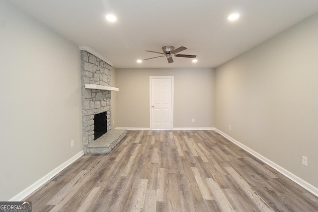413 Spring Village Rd SE, Lindale, GA 30147 - unfurnished living room featuring ceiling fan, recessed lighting, wood finished floors, and a stone fireplace