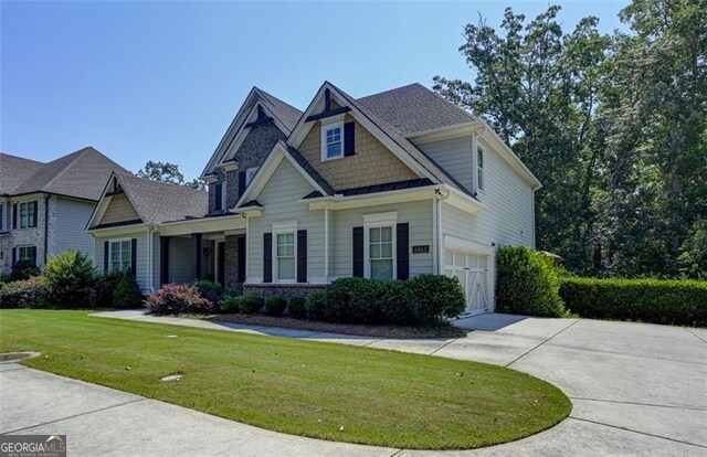 6863 Lake Sterling, Flowery Branch, GA 30542 - view of front of house featuring concrete driveway, a front yard, an attached garage, and a standing seam roof