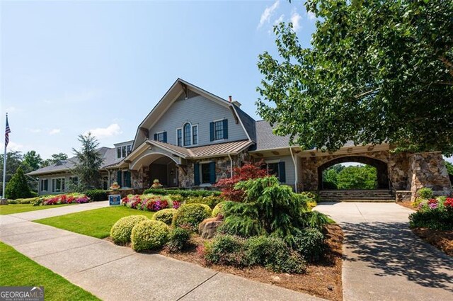 6863 Lake Sterling, Flowery Branch, GA 30542 - view of front of house featuring stone siding, a front yard, and a gambrel roof
