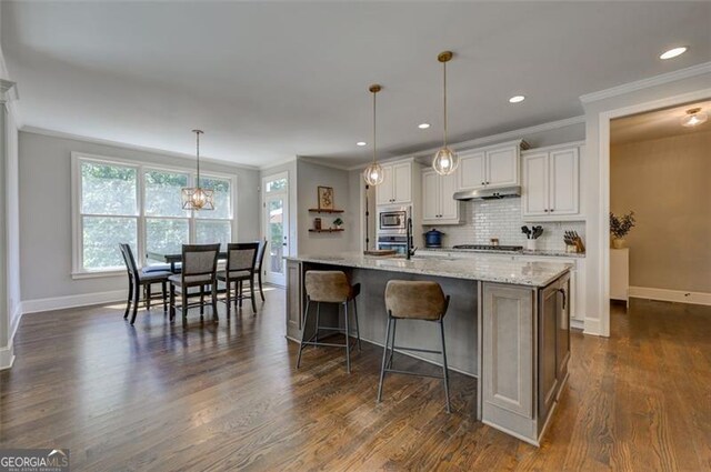 6863 Lake Sterling, Flowery Branch, GA 30542 - kitchen with ornamental molding, white cabinetry, tasteful backsplash, stainless steel appliances, and a breakfast bar area