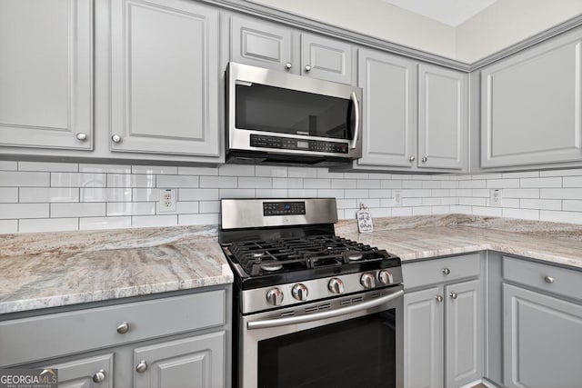 591 Wendlebury Ct, Alpharetta, GA 30004 - kitchen featuring appliances with stainless steel finishes, gray cabinets, backsplash, and light stone counters
