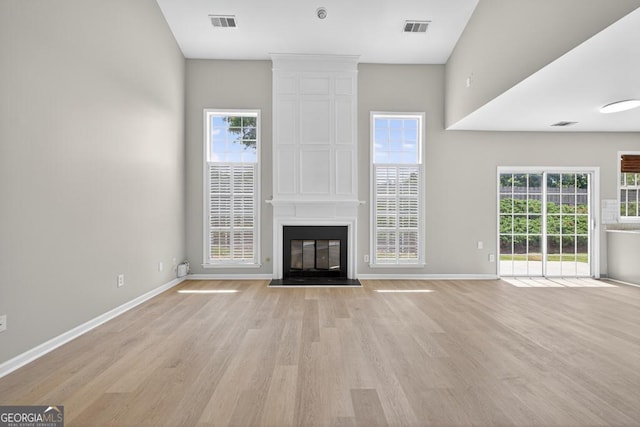 591 Wendlebury Ct, Alpharetta, GA 30004 - unfurnished living room with light wood-type flooring, a large fireplace, and a high ceiling