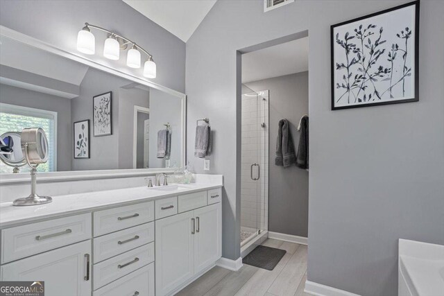 428 Gold Xing, Canton, GA 30114 - full bathroom with a stall shower, vaulted ceiling, double vanity, wood finished floors, and a tub