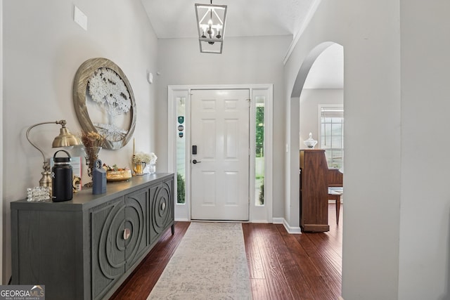 1535 Smoke Hill Dr, Hoschton, GA 30548 - entryway with dark wood finished floors, arched walkways, and a chandelier